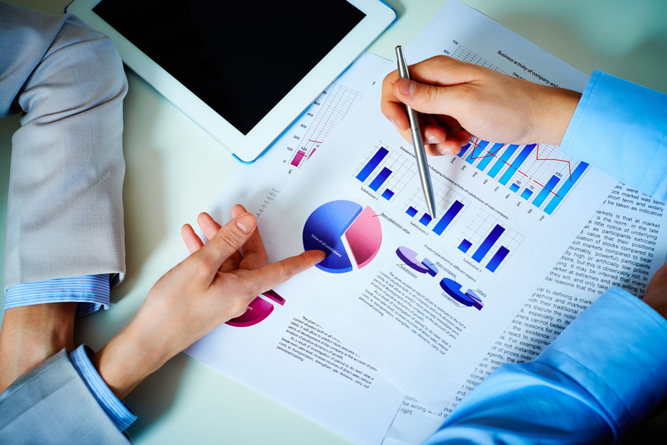 Close-up of female and male hands pointing at business document while discussing it